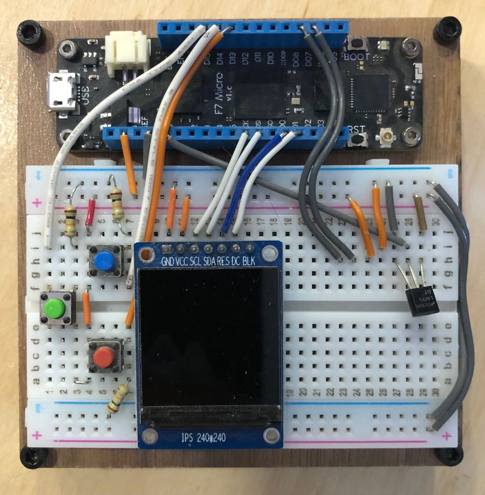 Photo of a Meadow board connected to a breadboard with a display and three buttons with resistors.
