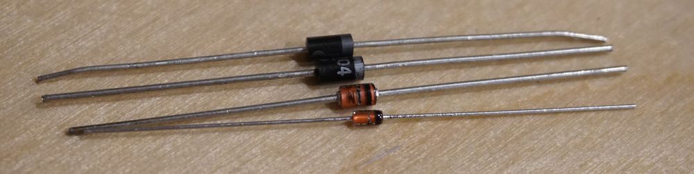 Photo of four diodes showing a colored band on each diode indicating the cathode side.
