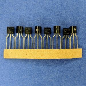 Photo of severael 2N3904 NPN transistors taped by their legs.