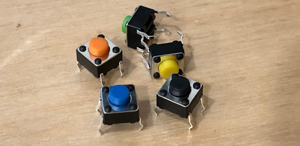 Photo of five push buttons with different color buttons.